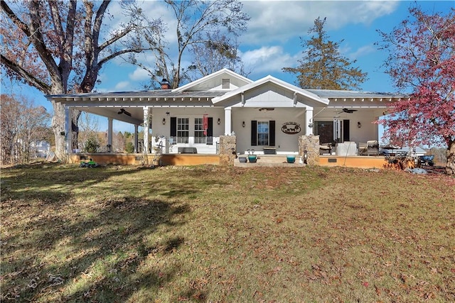 back of house with a lawn, ceiling fan, and covered porch