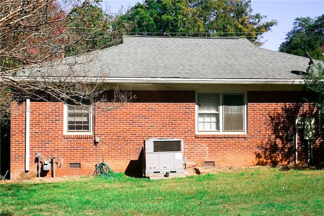 view of home's exterior with a yard and central AC