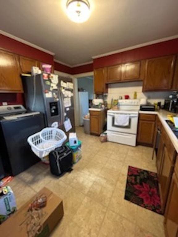 kitchen featuring electric range, stainless steel fridge, washer / dryer, and ornamental molding