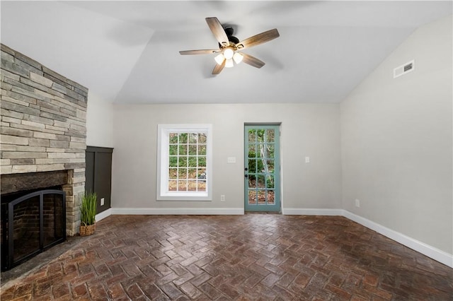 unfurnished living room with a stone fireplace, ceiling fan, and lofted ceiling