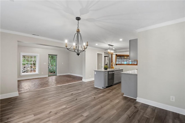 interior space featuring gray cabinets, a center island with sink, pendant lighting, and appliances with stainless steel finishes