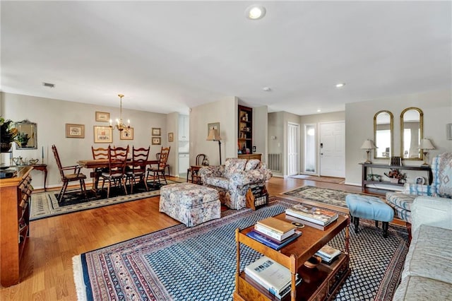 living room with wood-type flooring and a notable chandelier