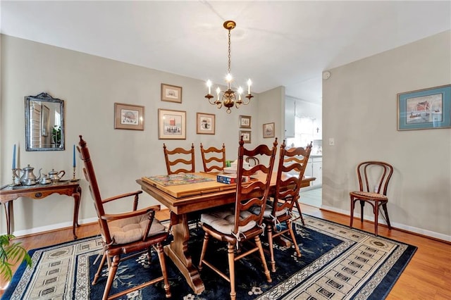 dining room with hardwood / wood-style floors and a chandelier