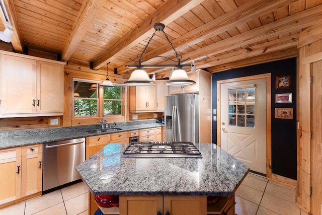 kitchen with a center island, light tile patterned flooring, light brown cabinets, and appliances with stainless steel finishes