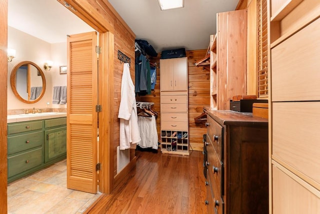 walk in closet featuring light hardwood / wood-style flooring and sink