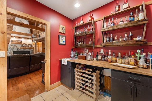 bar featuring a fireplace, light hardwood / wood-style flooring, and sink