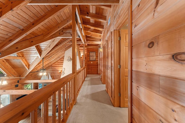 corridor with vaulted ceiling with beams, wood walls, and wood ceiling