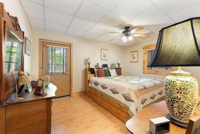 bedroom with a paneled ceiling, hardwood / wood-style flooring, and ceiling fan