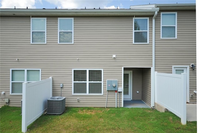 rear view of house with a patio, a yard, and central AC