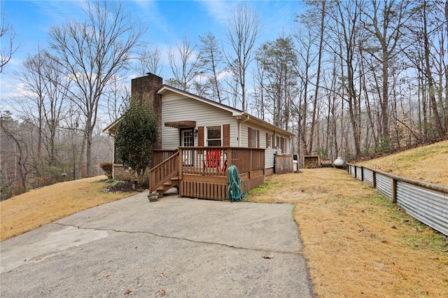 view of side of home with a lawn and a deck