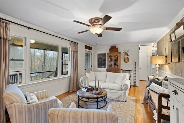 living room with ceiling fan, light hardwood / wood-style floors, and ornamental molding