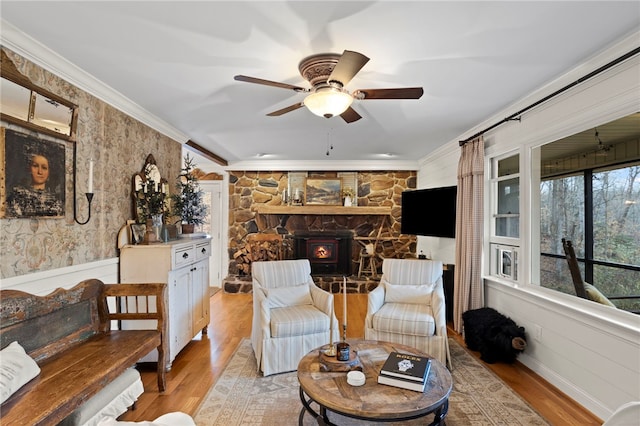 living room with a wood stove, ornamental molding, and light wood-type flooring