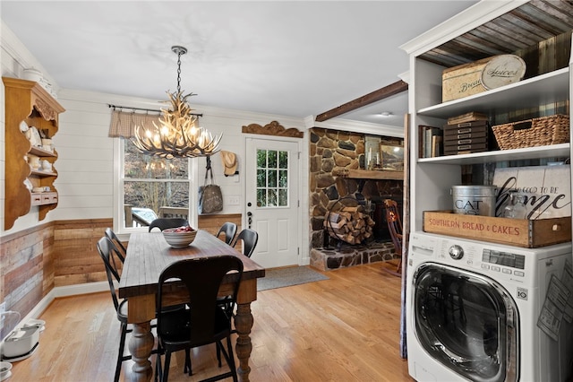 dining room featuring washer / clothes dryer, a chandelier, crown molding, and light hardwood / wood-style floors