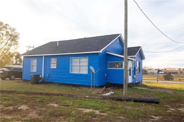 view of side of property featuring a yard and cooling unit