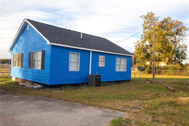 view of side of home featuring a yard and cooling unit