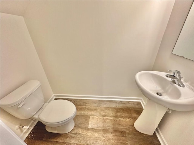 bathroom featuring hardwood / wood-style flooring and toilet