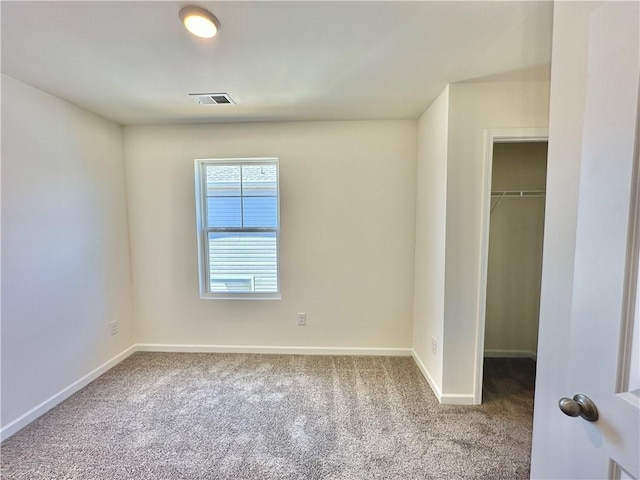 unfurnished bedroom featuring carpet floors, a spacious closet, and a closet