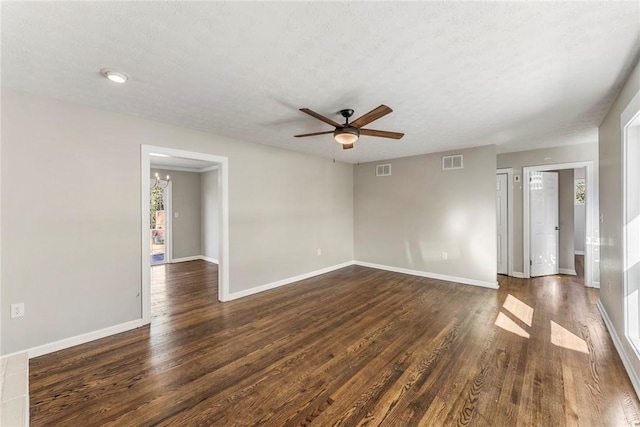 empty room featuring a textured ceiling, dark hardwood / wood-style floors, and ceiling fan with notable chandelier