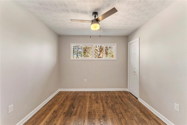 unfurnished room with a textured ceiling, dark hardwood / wood-style floors, and ceiling fan