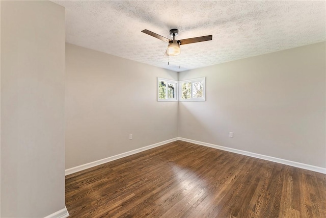 spare room featuring dark hardwood / wood-style floors, ceiling fan, and a textured ceiling