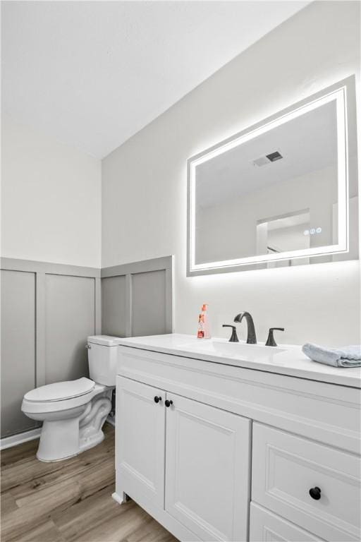 bathroom featuring hardwood / wood-style flooring, vanity, and toilet