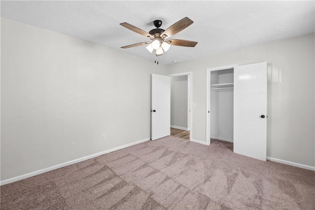 unfurnished bedroom featuring light carpet, a closet, and ceiling fan