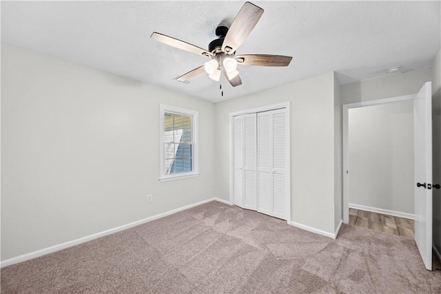 unfurnished bedroom with ceiling fan, light colored carpet, and a closet