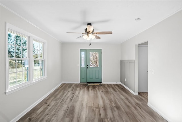 foyer with ceiling fan, a healthy amount of sunlight, crown molding, and light hardwood / wood-style flooring