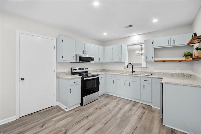 kitchen featuring an inviting chandelier, sink, stainless steel appliances, and light hardwood / wood-style flooring