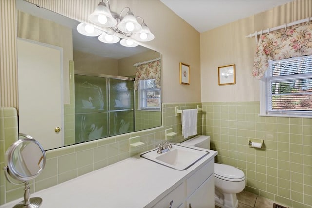 bathroom featuring tile patterned floors, an enclosed shower, toilet, vanity, and tile walls