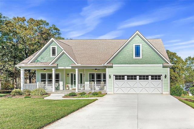 craftsman-style house featuring a garage, covered porch, and a front lawn