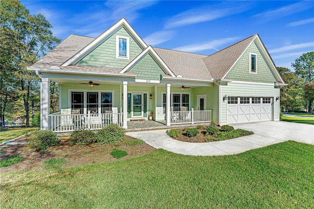 craftsman-style house featuring covered porch, a garage, and a front lawn