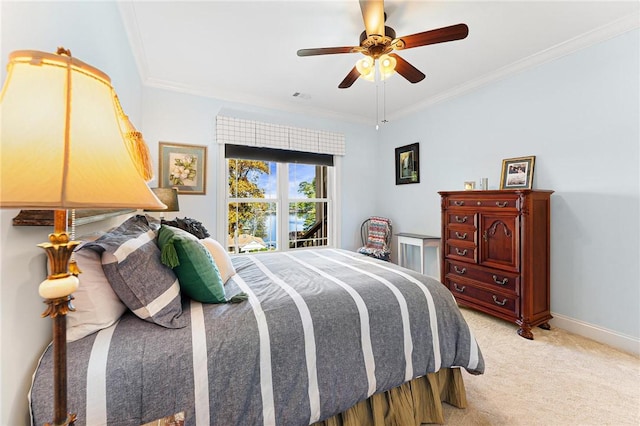 carpeted bedroom with ceiling fan and ornamental molding