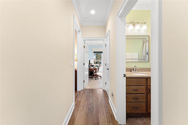 hall with wood-type flooring, ornamental molding, and sink