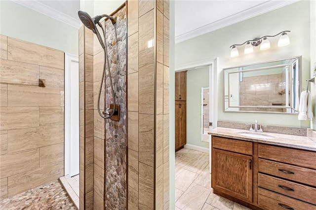 bathroom featuring a tile shower, vanity, and crown molding