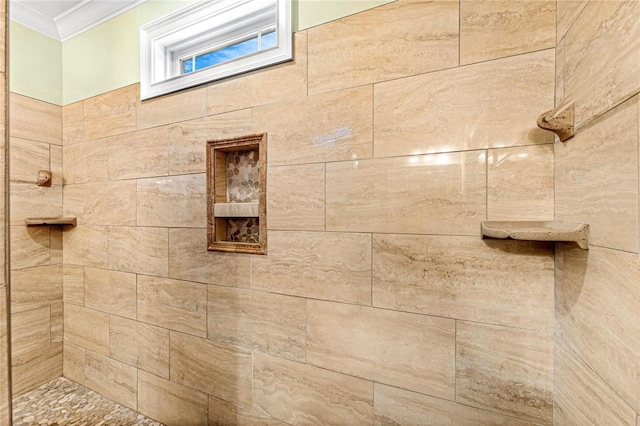 bathroom with a tile shower and ornamental molding