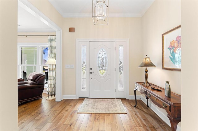 foyer featuring crown molding, light hardwood / wood-style flooring, and an inviting chandelier