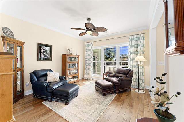 sitting room featuring ceiling fan, wood-type flooring, and crown molding