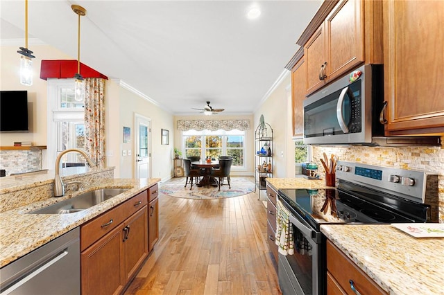 kitchen featuring ceiling fan, sink, decorative backsplash, appliances with stainless steel finishes, and ornamental molding