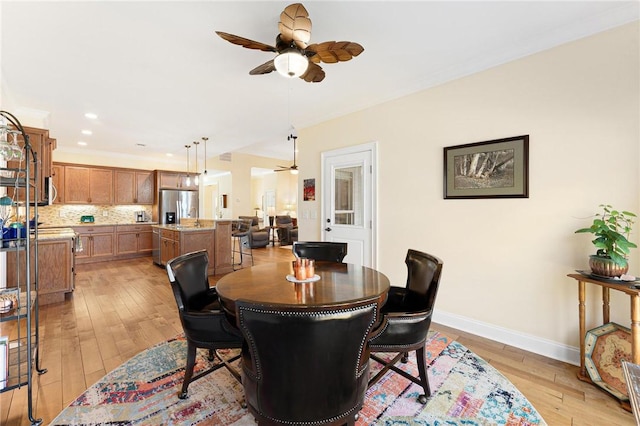 dining space with light hardwood / wood-style floors, ceiling fan, and sink