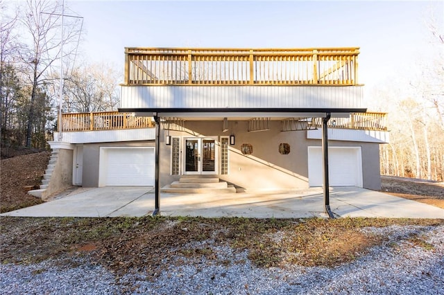 rear view of property featuring french doors and a garage