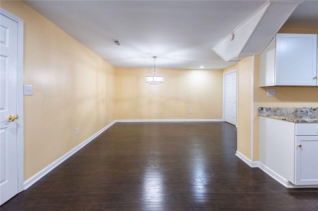 unfurnished dining area with dark wood-type flooring