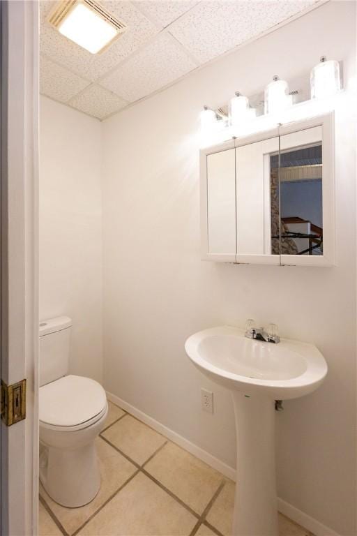 bathroom with tile patterned floors, a paneled ceiling, and toilet