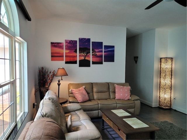 living area featuring wood finished floors, a ceiling fan, and baseboards