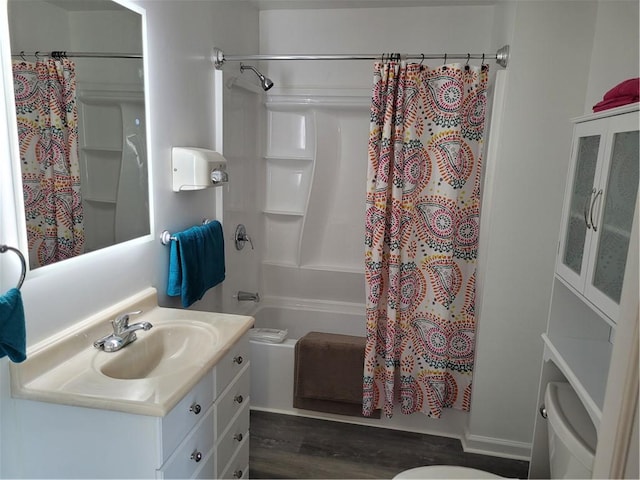 bathroom featuring toilet, shower / bathtub combination with curtain, and vanity