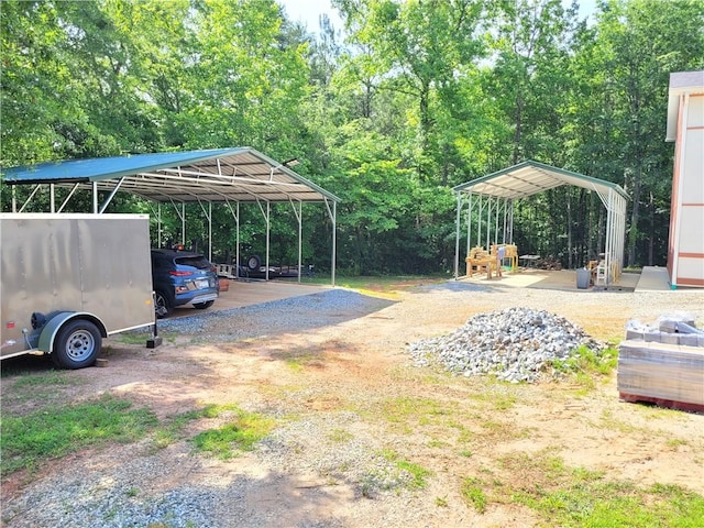 view of parking / parking lot featuring dirt driveway and a carport