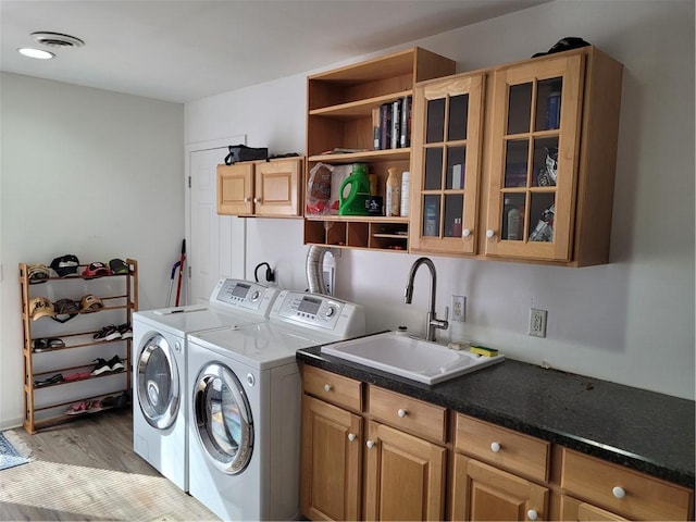 laundry room with washer and dryer, cabinet space, visible vents, a sink, and light wood-type flooring