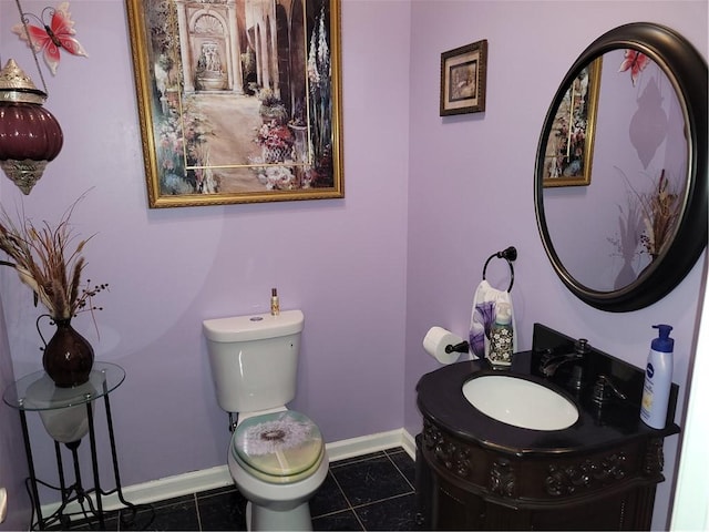 half bathroom featuring tile patterned flooring, toilet, vanity, and baseboards