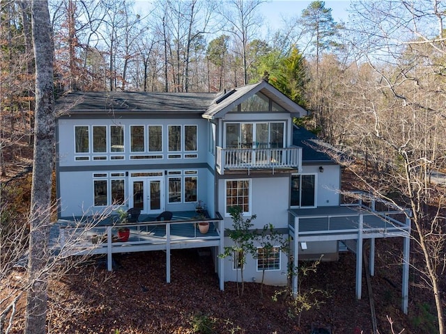 rear view of house featuring a balcony, a deck, and french doors