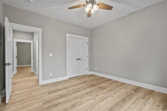 unfurnished bedroom with ceiling fan, a closet, and light wood-type flooring